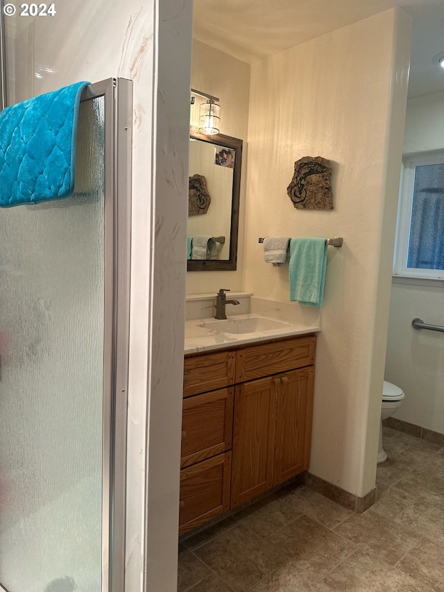 bathroom with a shower, vanity, and toilet