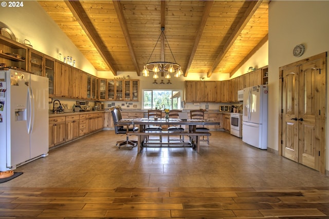 kitchen featuring white appliances, pendant lighting, high vaulted ceiling, beamed ceiling, and a chandelier