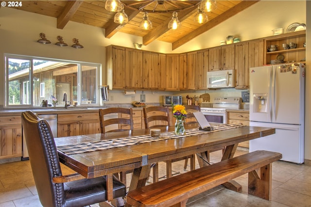 kitchen with lofted ceiling with beams, light tile patterned flooring, white appliances, and wooden ceiling