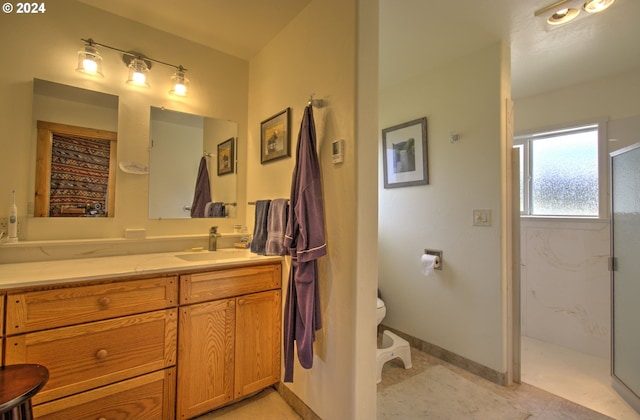 bathroom with vanity, toilet, and a shower with door