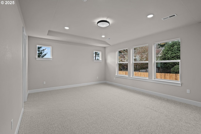 carpeted empty room with a tray ceiling