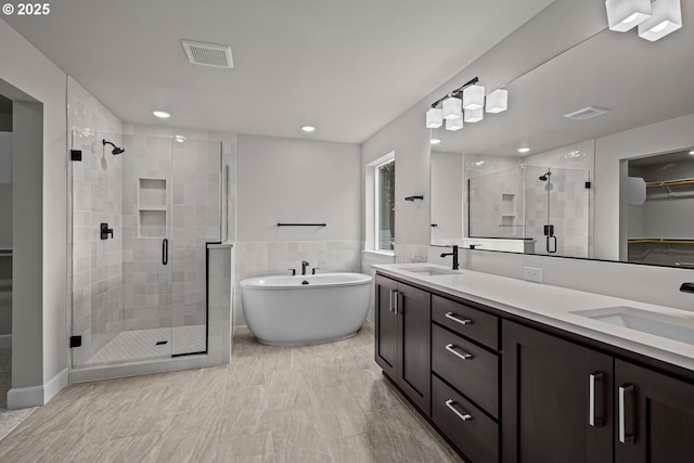 bathroom with vanity and shower with separate bathtub