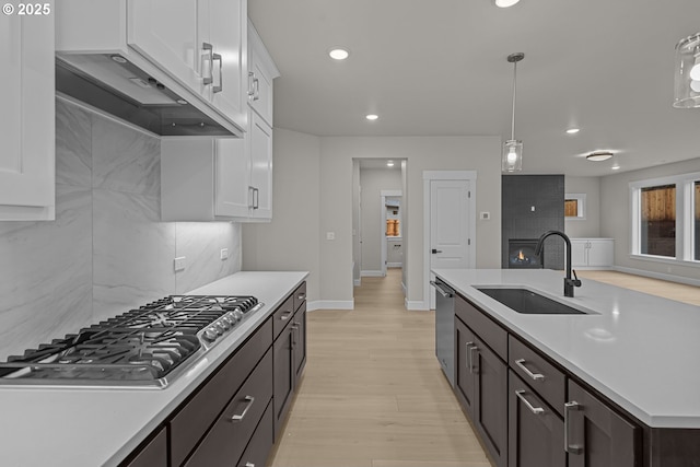 kitchen featuring white cabinets, appliances with stainless steel finishes, sink, and decorative light fixtures