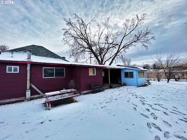 view of snow covered rear of property