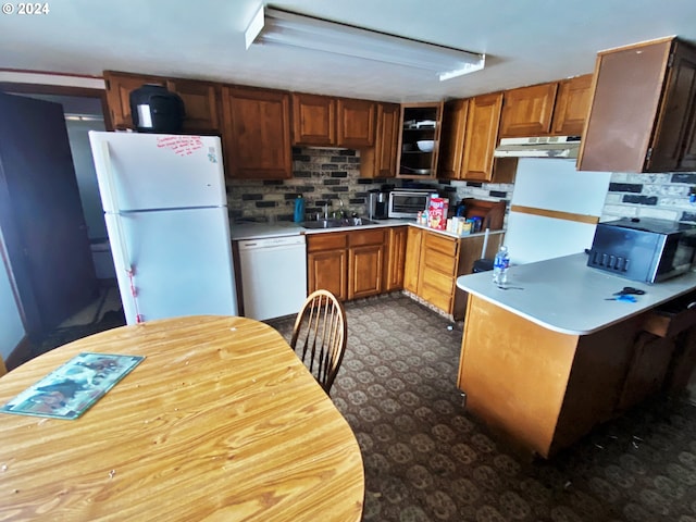 kitchen with backsplash, sink, and white appliances