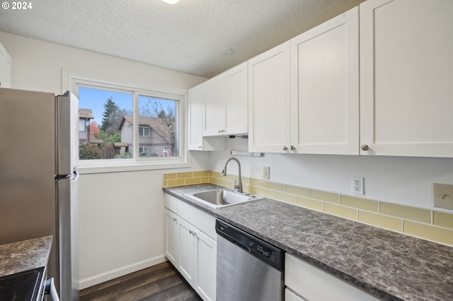 kitchen featuring appliances with stainless steel finishes, dark hardwood / wood-style flooring, a textured ceiling, sink, and white cabinetry