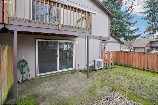 rear view of property featuring ac unit, a balcony, and a lawn