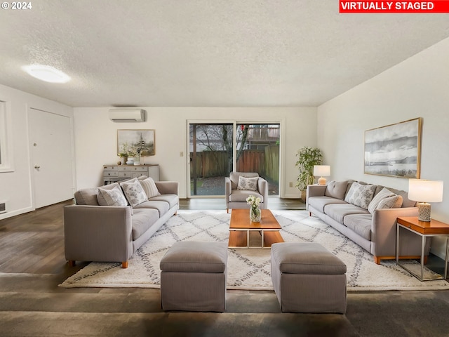 living room featuring wood-type flooring, a textured ceiling, and a wall mounted AC