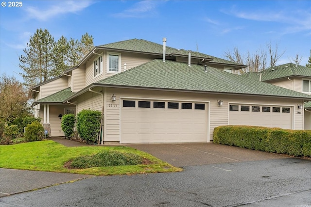 view of front of property with a garage, aphalt driveway, a front lawn, and a shingled roof