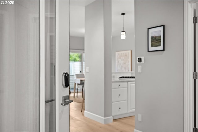 hallway with light wood-style flooring and baseboards