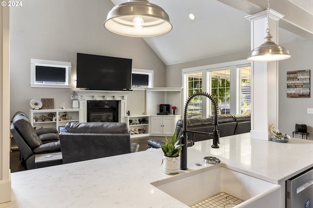 kitchen with white cabinetry, sink, light stone countertops, pendant lighting, and hardwood / wood-style flooring