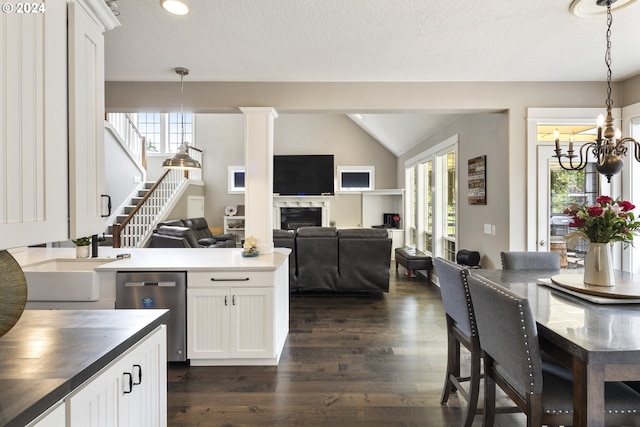 kitchen with dishwasher, white cabinetry, an inviting chandelier, lofted ceiling, and dark hardwood / wood-style flooring