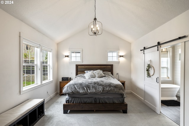 carpeted bedroom featuring vaulted ceiling, ensuite bath, a barn door, and a chandelier