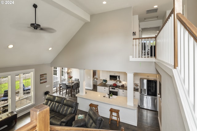 living room featuring ceiling fan, high vaulted ceiling, and dark wood-type flooring