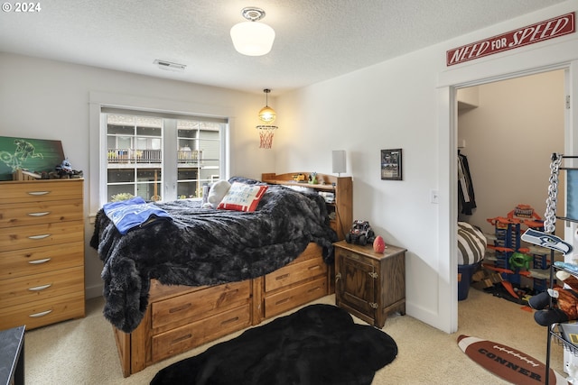 bedroom featuring light carpet and a textured ceiling