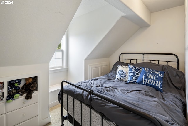 bedroom with vaulted ceiling and light colored carpet