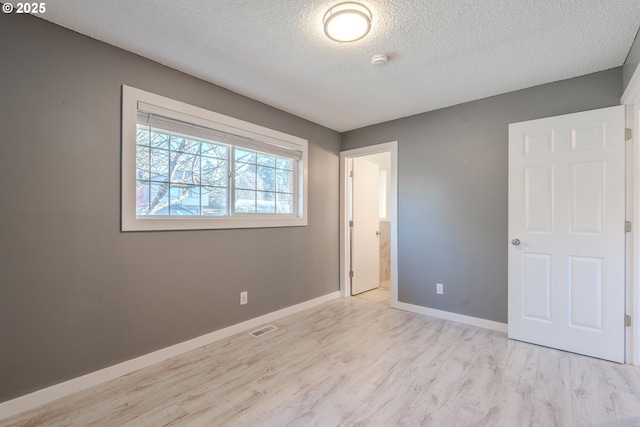 unfurnished bedroom featuring a textured ceiling and light wood-type flooring