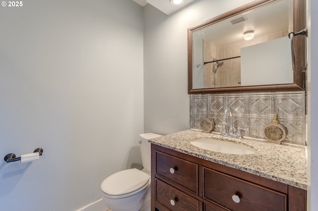 bathroom with vanity, backsplash, and toilet