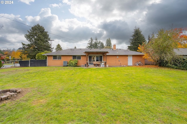 back of property with a yard, central AC unit, and a patio area