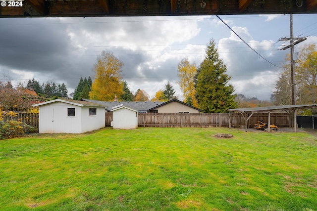 view of yard featuring a storage shed and an outdoor fire pit