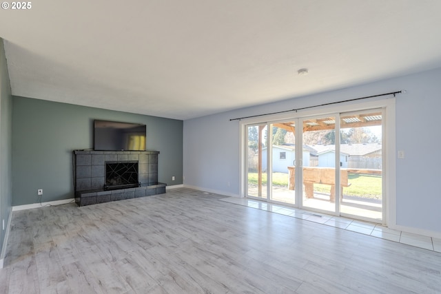 unfurnished living room with light hardwood / wood-style flooring and a tile fireplace