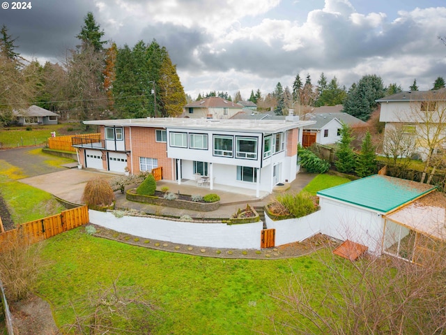 back of house featuring a lawn and a garage