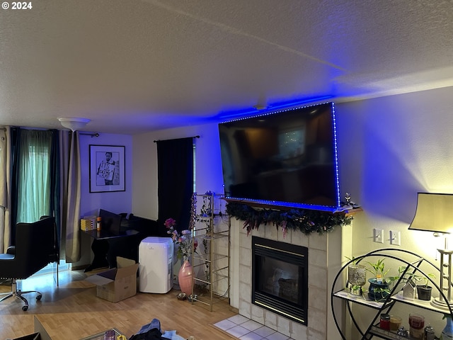 living room featuring a fireplace, hardwood / wood-style flooring, and a textured ceiling