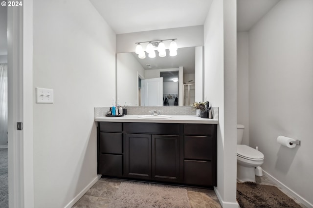 bathroom featuring vanity, toilet, and walk in shower