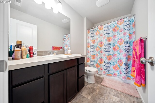 bathroom with vanity, toilet, curtained shower, and tasteful backsplash