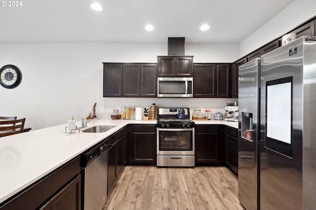 kitchen featuring light hardwood / wood-style floors, kitchen peninsula, sink, appliances with stainless steel finishes, and dark brown cabinetry