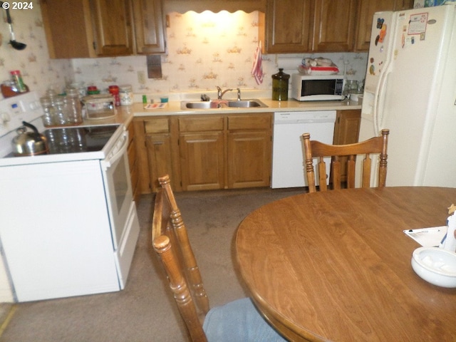 kitchen with light carpet, white appliances, and sink