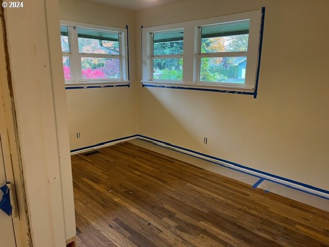 unfurnished room featuring a wealth of natural light and hardwood / wood-style flooring