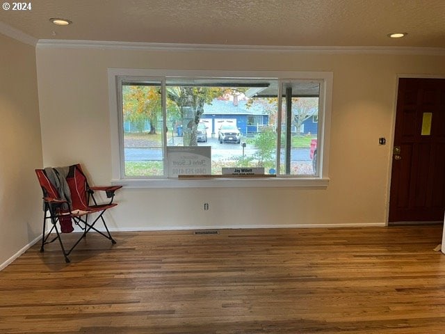 interior space with ornamental molding, hardwood / wood-style floors, and a textured ceiling