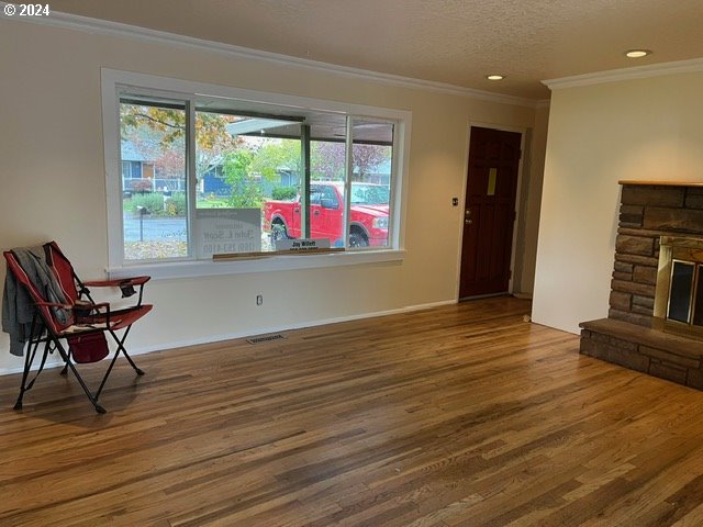 319 Charlotte Way, Vancouver, WA 98664 - unfurnished room featuring crown molding, wood finished floors, plenty of natural light, a fireplace, and recessed lighting