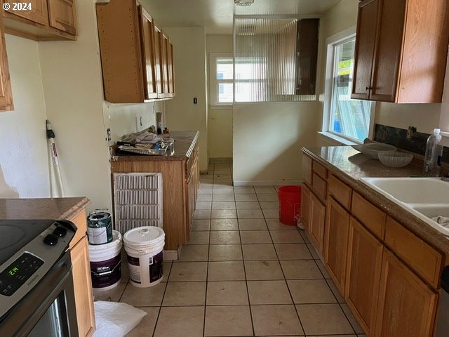 319 Charlotte Way, Vancouver, WA 98664 - kitchen featuring electric range, light tile patterned flooring, brown cabinetry, and a sink