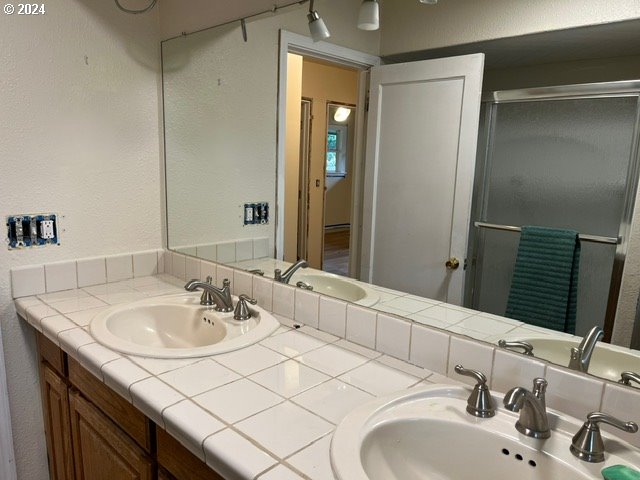 319 Charlotte Way, Vancouver, WA 98664 - bathroom featuring a textured wall, a shower stall, and double vanity