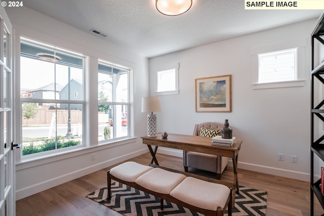 office area featuring light hardwood / wood-style flooring and a textured ceiling