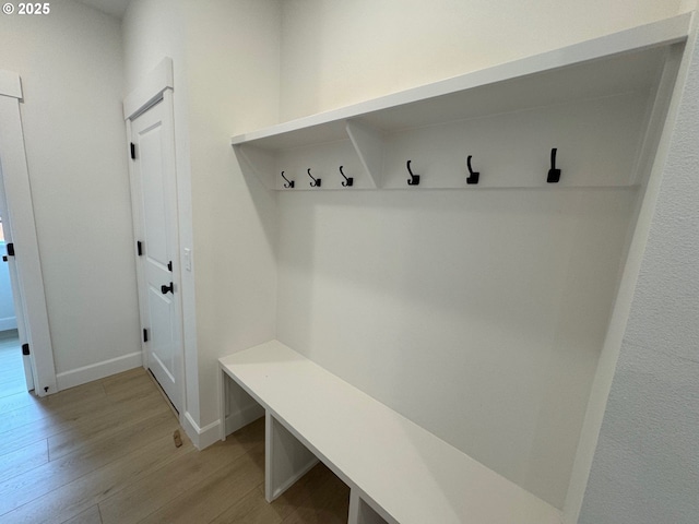 mudroom featuring light wood-style flooring and baseboards