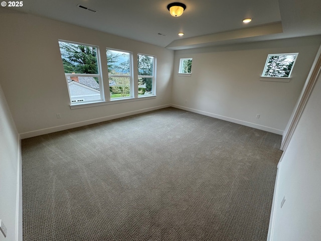 empty room featuring carpet floors, baseboards, visible vents, and recessed lighting