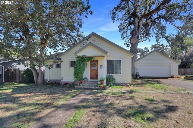 view of front of home featuring a front lawn, an outdoor structure, and a garage