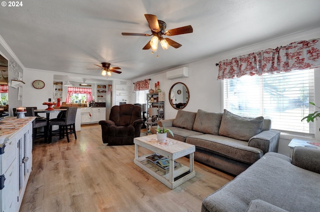 living room featuring ornamental molding, ceiling fan, a wall unit AC, and light hardwood / wood-style flooring