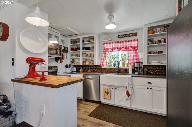 kitchen featuring light wood-type flooring, white cabinetry, hanging light fixtures, stainless steel appliances, and butcher block countertops