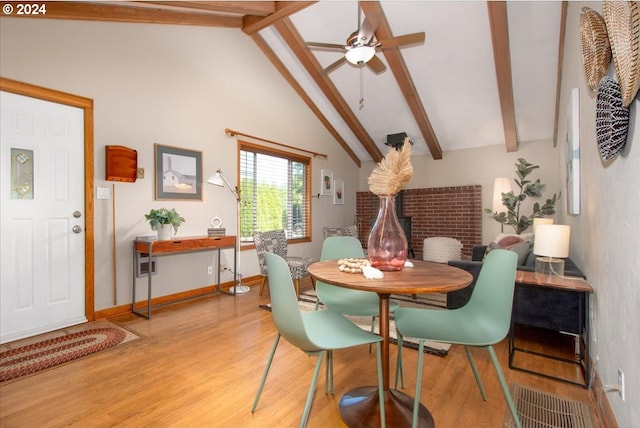 dining room with ceiling fan, light hardwood / wood-style floors, beam ceiling, and high vaulted ceiling