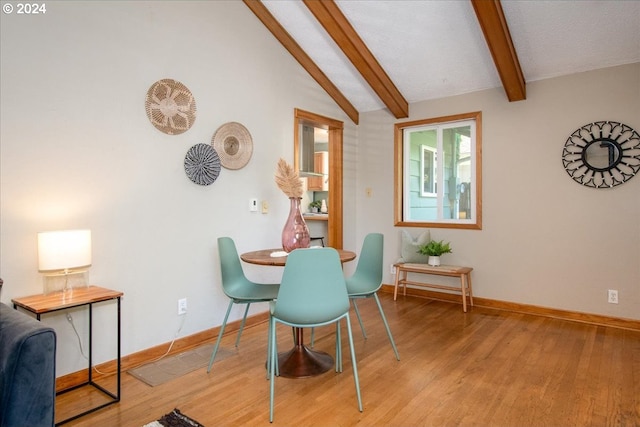 dining area with lofted ceiling with beams and light hardwood / wood-style flooring