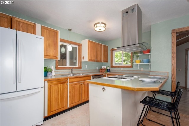 kitchen with white appliances, pendant lighting, a kitchen bar, island exhaust hood, and sink