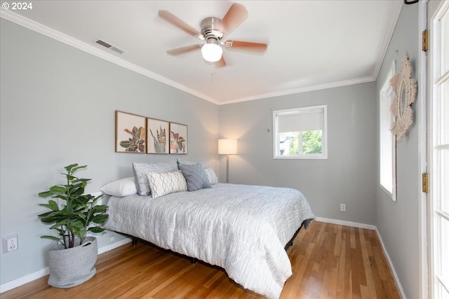 bedroom featuring ceiling fan, ornamental molding, and hardwood / wood-style flooring