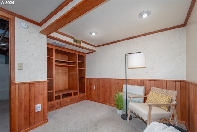 unfurnished room featuring light colored carpet, built in shelves, and crown molding