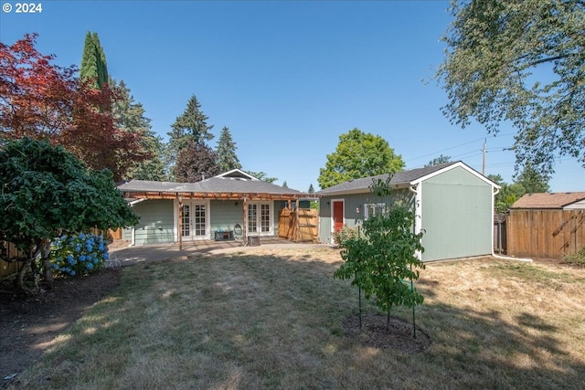 back of property with a yard and a patio