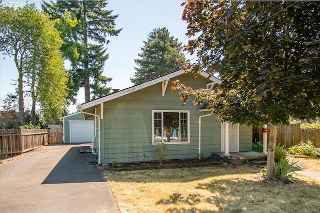 view of home's exterior with a garage, a yard, and an outdoor structure