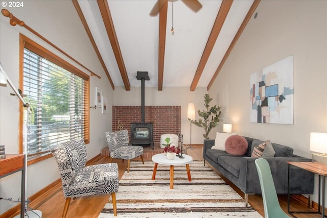 living room featuring ceiling fan, a wood stove, hardwood / wood-style floors, and lofted ceiling with beams